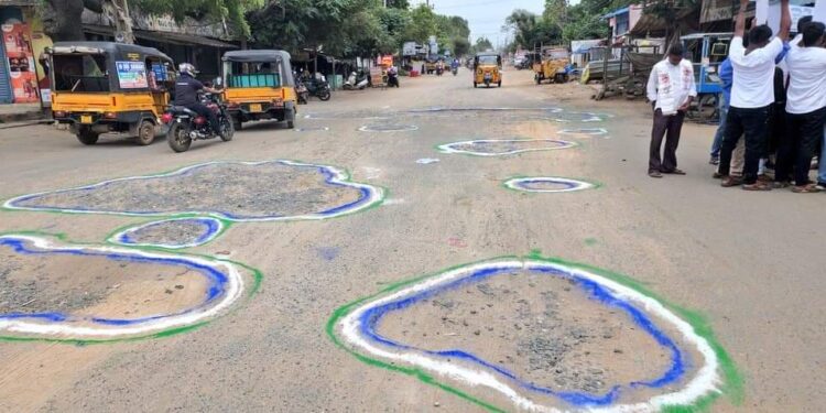 రోడ్డు గుంతలకి వైసీపీ రంగులు వేసిన జనసేన నాయకులు